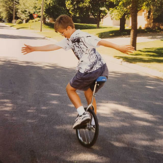 Paul Boswell riding unicycle as a young boy