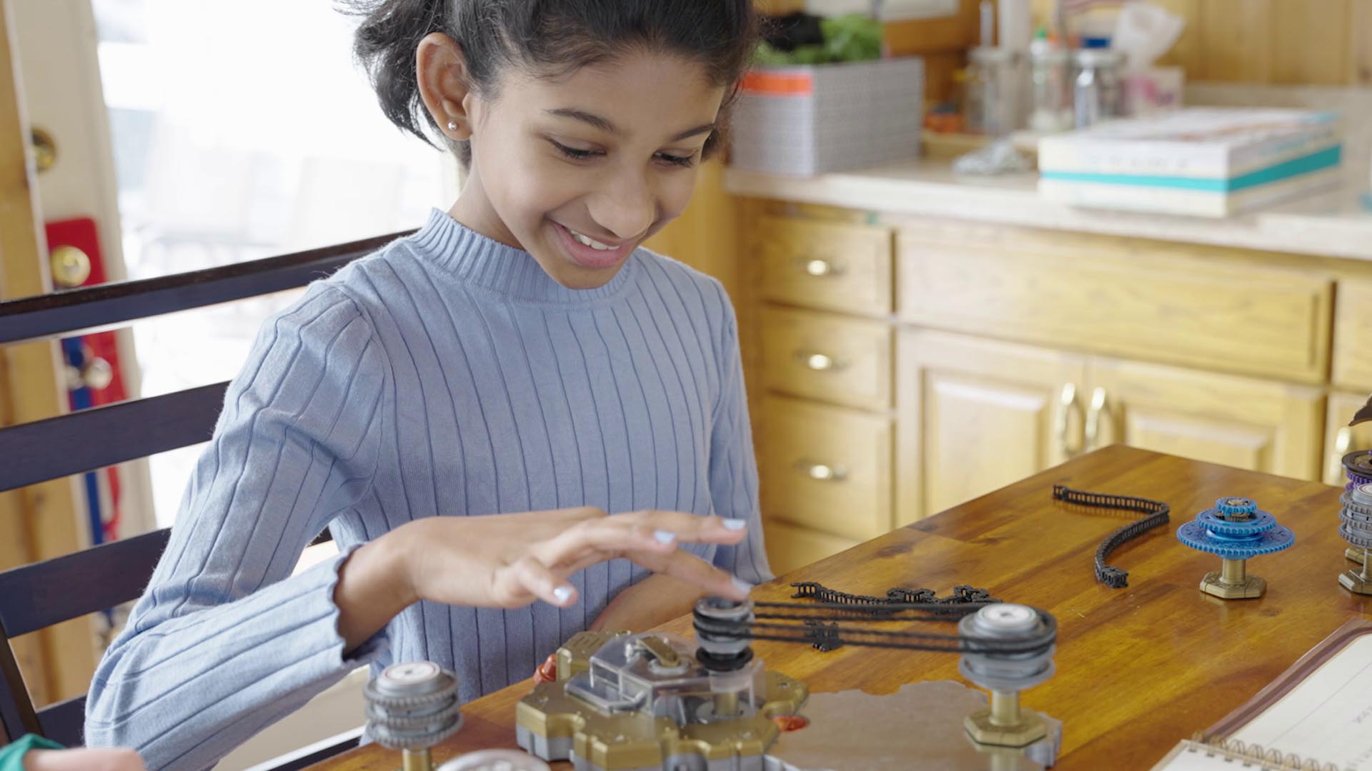 Girl playing with Spintronics, putting resistance on the battery with her finger.
