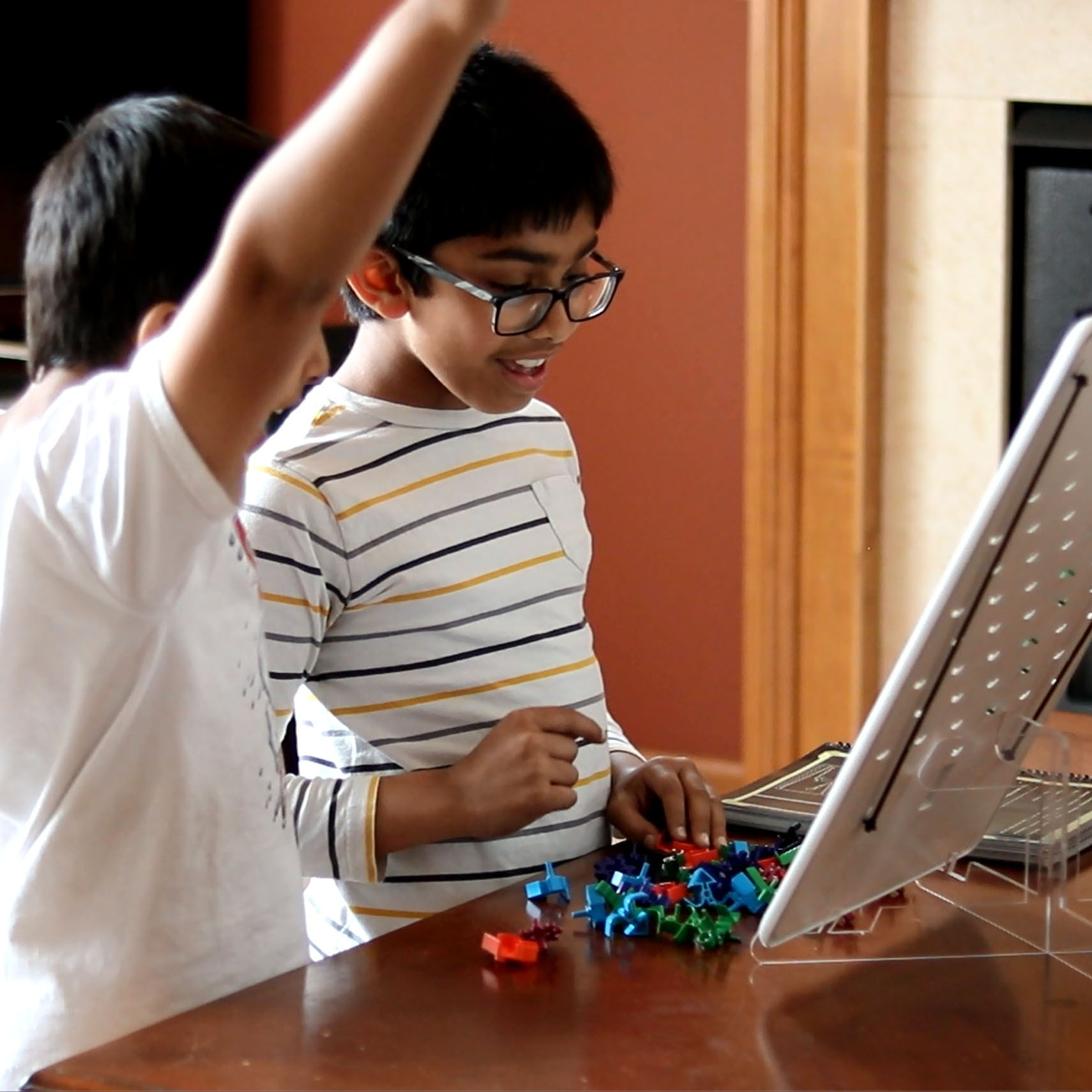 two boys with arms raised solving a puzzle